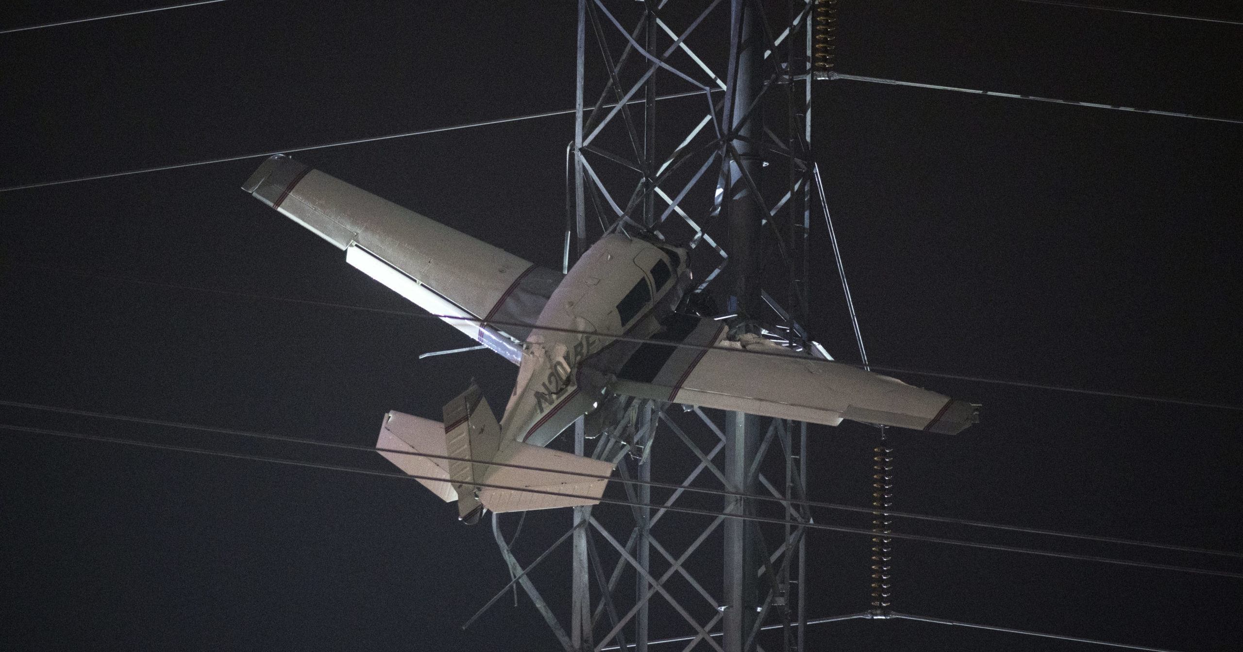 A small plane rests on live power lines after crashing into a tower in Montgomery Village, Maryland, on Sunday.