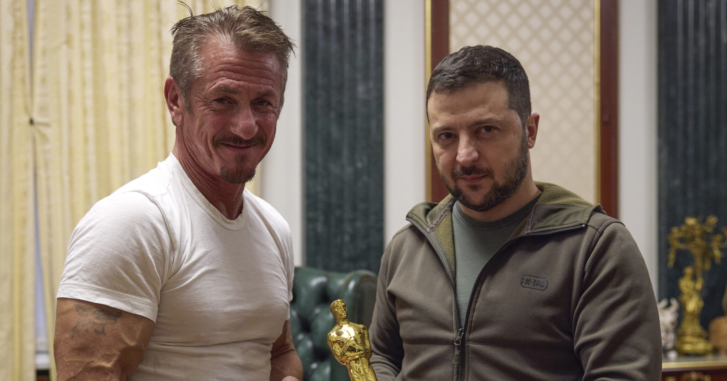 In this photo provided by the Ukrainian Press Office, Ukrainian President Volodymyr Zelesky, right, poses with U.S. actor Sean Penn, left, after receiving the latter's Oscar statuette and handing him the Order of Merit, III degree during a meeting in Kyiv, Ukraine, on Tuesday.