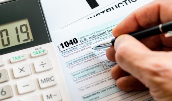 A person fills out an IRS 1040 tax form.
