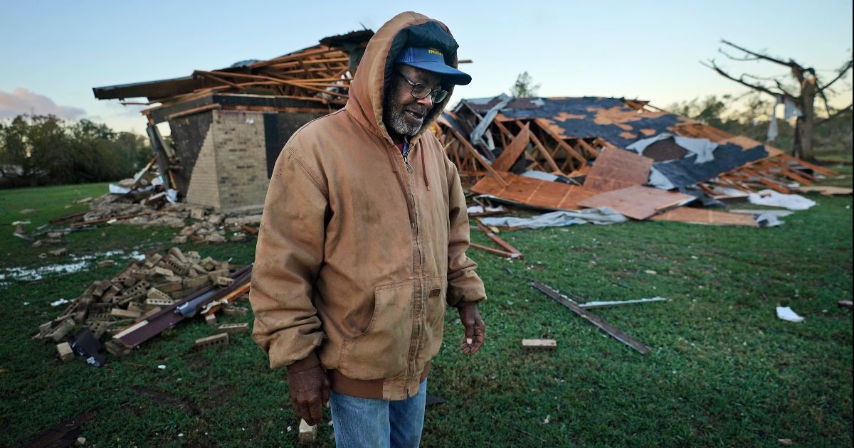 Willie Meeds walks in front of a relative's destroyed home after a tornado hit Powderly, Texas, on Saturday.
