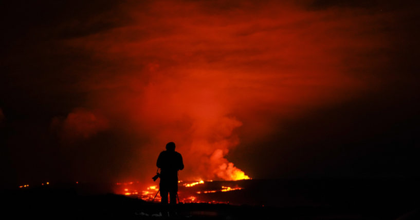 A photographer takes pictures of the erupting Mauna Loa volcano on Wednesday near Hilo, Hawaii.