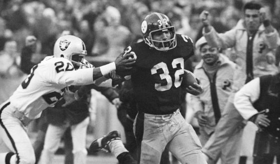 Pittsburgh Steelers’ Franco Harris eludes a tackle by Oakland Raiders’ Jimmy Warren as he runs 42-yards for a touchdown after catching a deflected pass during an AFC Divisional NFL football playoff game in Pittsburgh on Dec. 23, 1972.
