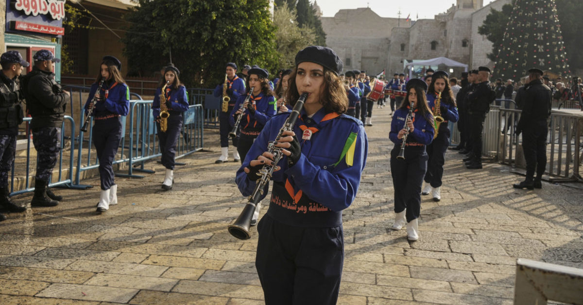 Girls scouts march during Christmas parade in Manger Square in Bethlehem