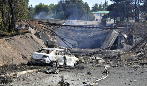 A burned-out vehicle marks the spot where a gas tanker exploded under a bridge in Boksburg, east of Johannesburg, South Africa, Saturday. A truck carrying liquified petroleum gas exploded, killing at least 8 people and injuring more than 50 others.