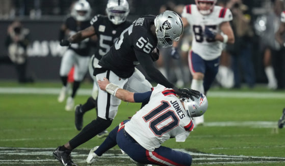 Las Vegas Raiders defensive end Chandler Jones breaks a tackle by New England Patriots quarterback Mac Jones to score a touchdown on an interception during the second half of an NFL football game between the New England Patriots and Las Vegas Raiders in Las Vegas on Sunday.