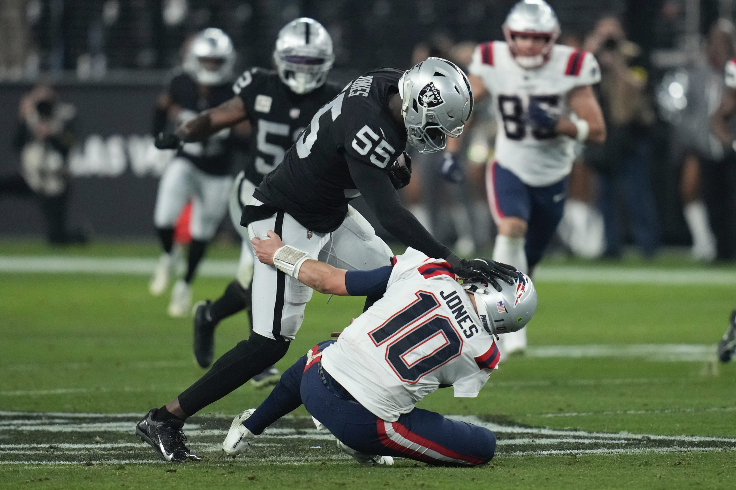 Las Vegas Raiders defensive end Chandler Jones breaks a tackle by New England Patriots quarterback Mac Jones to score a touchdown on an interception during the second half of an NFL football game between the New England Patriots and Las Vegas Raiders in Las Vegas on Sunday.