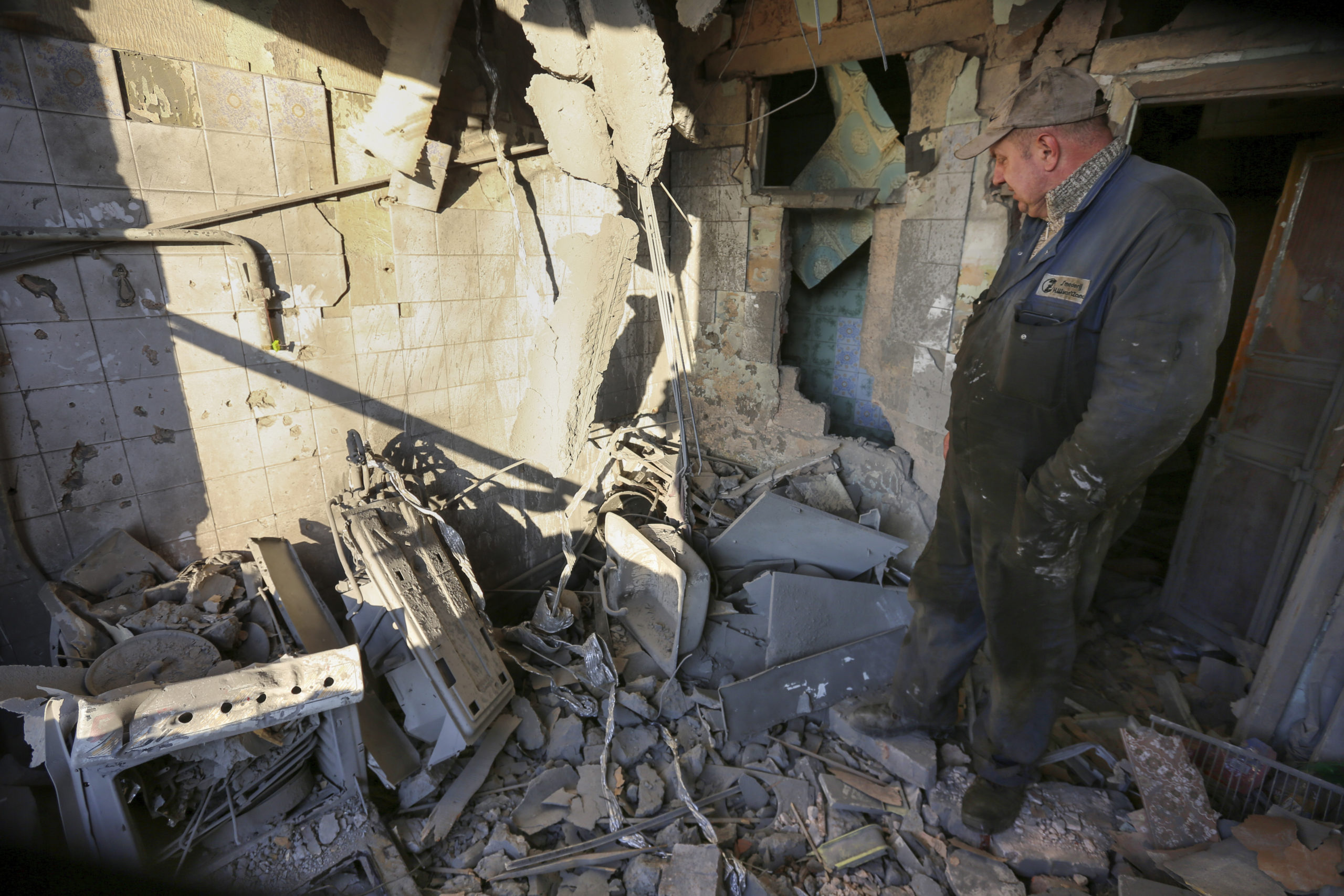 A man examines a damaged apartment building Thursday after what Russian officials said was a shelling by Ukrainian forces in the capital of the Russian-controlled Donetsk region in eastern Ukraine.