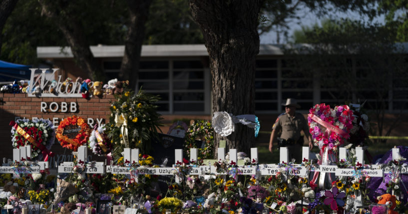 Flowers and candles are placed around crosses on May 28 at a memorial outside of Robb Elementary School in Uvalde, Texas.