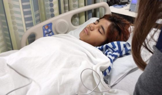 An injured Aiden lays in a hospital bed.
