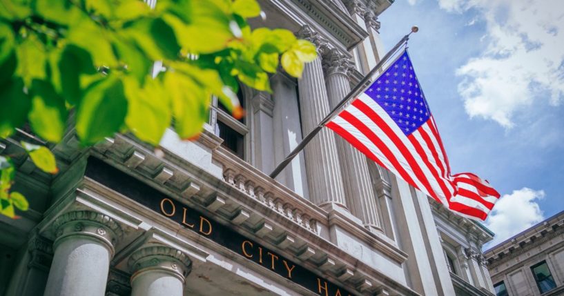 An American flag flies outside a building in this stock image.