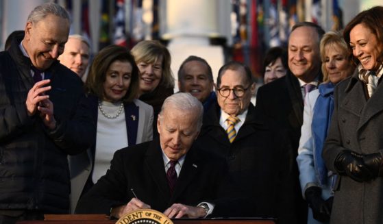 President Joe Biden signs the "Respect for Marriage Act" on the South Lawn of the White House while surrounded by several prominent Democrats on Tuesday.