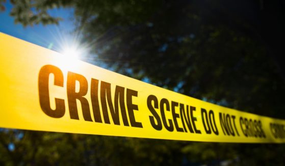 This stock photo shows police tape outside of a crime scene in a rural area.