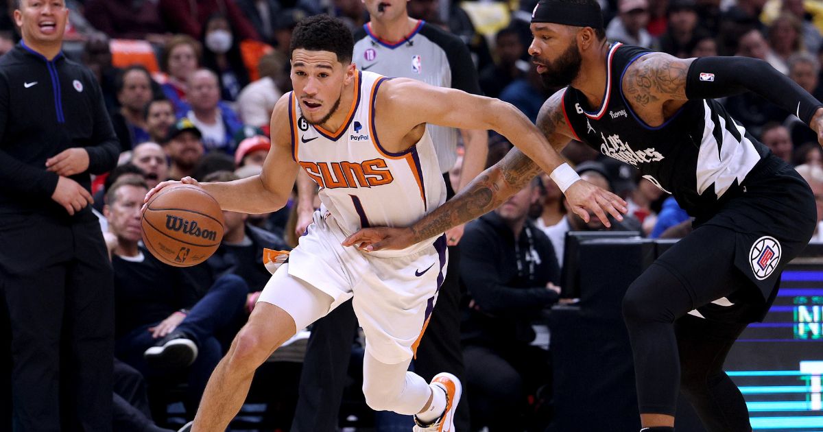 Devin Booker of the Phoenix Suns drives past Marcus Morris Sr. of the Los Angeles Clippers during a game at Crypto.com Arena on Thursday in Los Angeles.