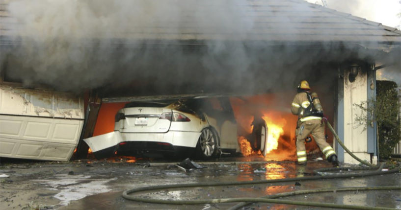 The Orange County Fire Authority battles a fire on a burning vehicle inside a garage in Orange County, California.