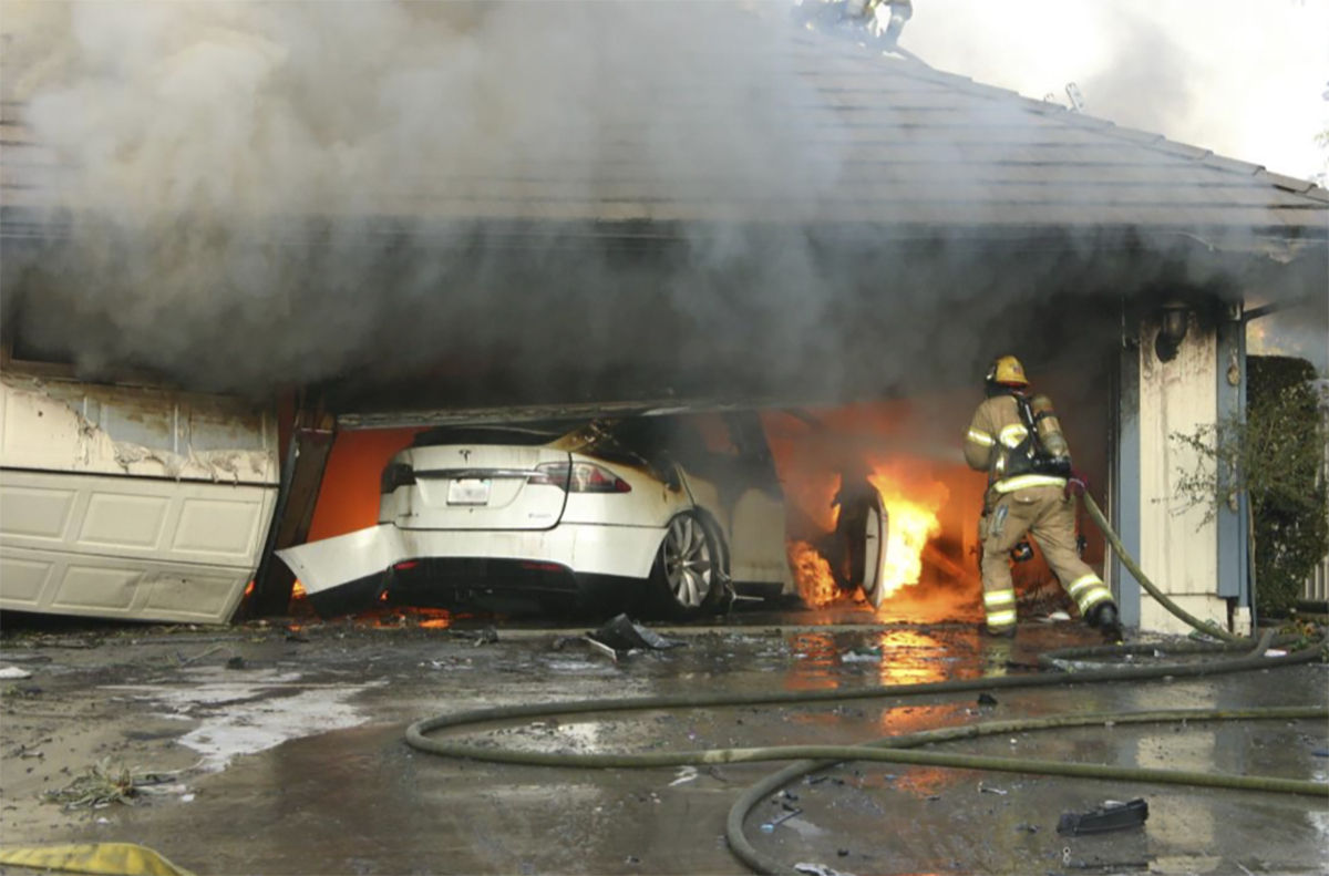 The Orange County Fire Authority battles a fire on a burning vehicle inside a garage in Orange County, California.