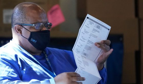 A worker at the Fulton County Board of Registration and Elections works to process absentee ballots at the State Farm Arena in Atlanta on Nov. 2, 2020.