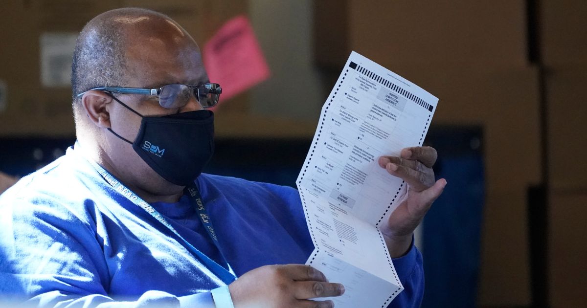 A worker at the Fulton County Board of Registration and Elections works to process absentee ballots at the State Farm Arena in Atlanta on Nov. 2, 2020.