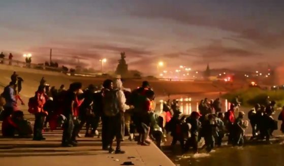 A large group of immigrants crosses the Rio Grande river into El Paso, Texas.