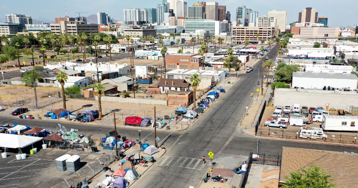 An aerial view shows people walking past a homeless encampment in Phoenix, Arizona, in July. The ACLU is suing to keep Phoenix from cleaning up the mess created by the unauthorized encampments.