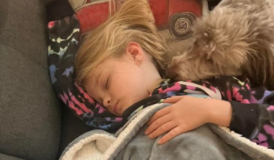 Pippa Daspit, 8, sleeps alongside her dog.
