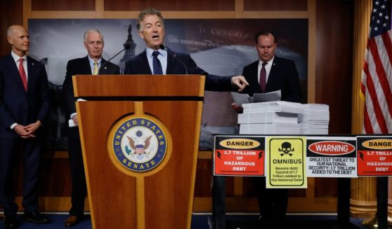 Sen. Rand Paul points to a printed copy of proposed federal omnibus spending legislation during a news conference on Dec. 20 in Washington, D.C