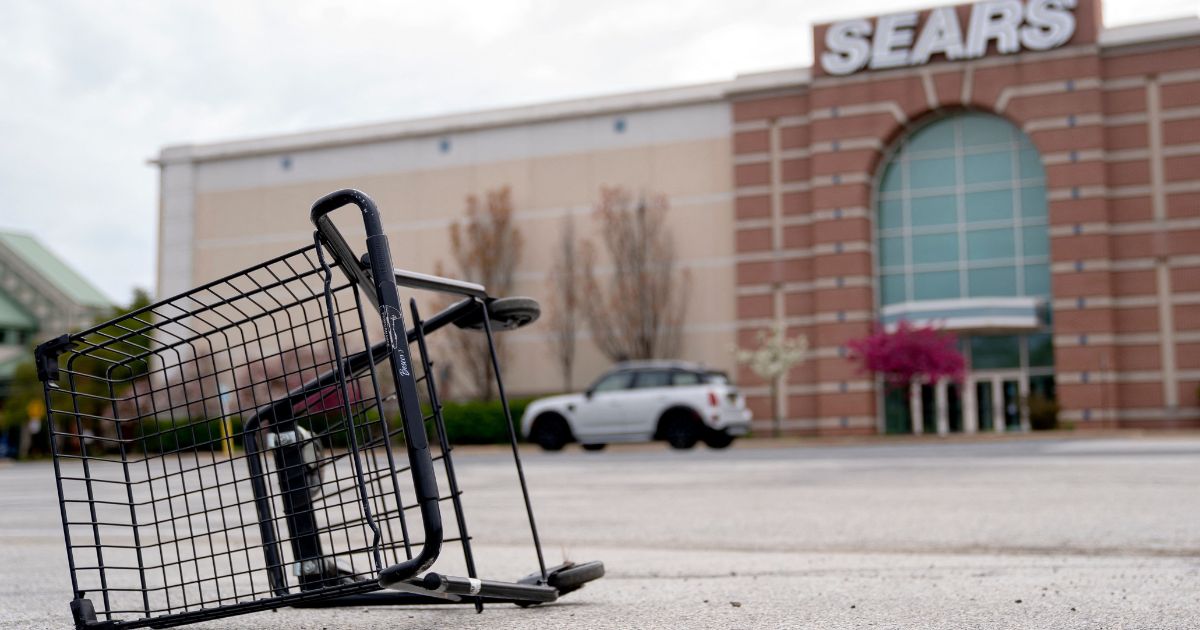 A shopping cart sits tipped over in the parking lot of a Sears store in Wilmington, Delaware, on April 23.