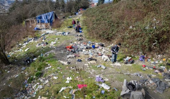 A group of people collect garbage surrounding a homeless encampment in Seattle, Washington, on March 12.