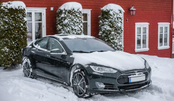 A Tesla Model S is parked in the snow next to a cottage in Tønsberg, Norway, on Feb. 19, 2021.