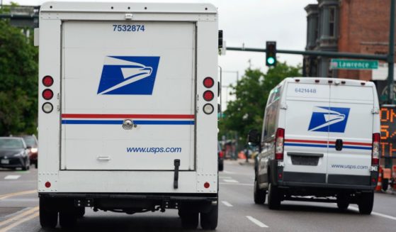 A USPS logo adorns the back doors of United States Postal Service delivery vehicles as they drive through Denver, Colorado, on June 1.