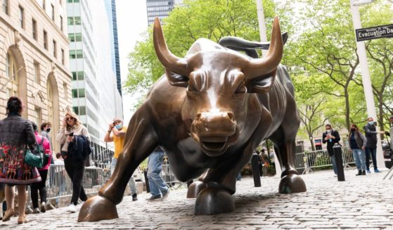 People visit the Charging Bull statue in Wall Street in New York City in a file photo from May, 2021.