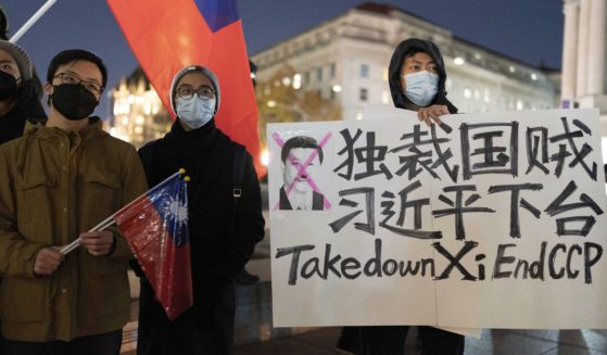 A demonstrator holds a sign to protest in solidarity with the Chinese protests at Freedom Plaza in Washington, D.C., on Sunday.