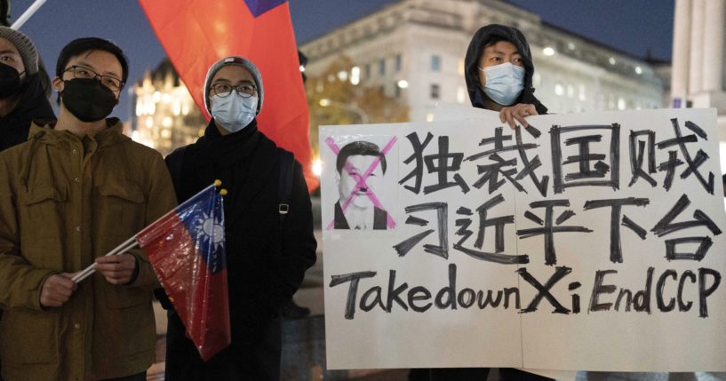 A demonstrator holds a sign to protest in solidarity with the Chinese protests at Freedom Plaza in Washington, D.C., on Sunday.