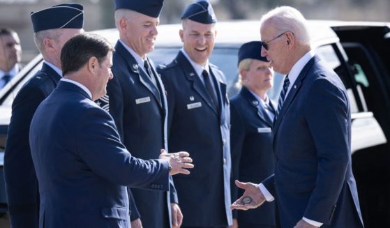 President Joe Biden hands a challenge coin to Arizona Governor Doug Ducey after disembarking from Air Force One at Luke Air Force Base in Glendale, Arizona, on Dec. 6.