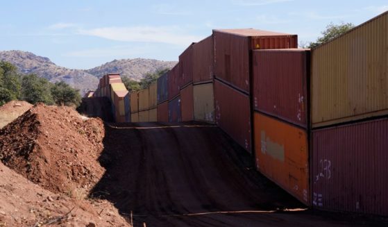 A long row of double-stacked shipping containers provides a new wall between the United States and Mexico in the remote section area of San Rafael Valley, Arizona.