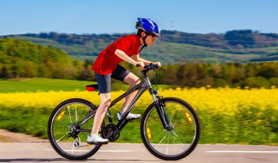 A boy rides a bike in this stock image.