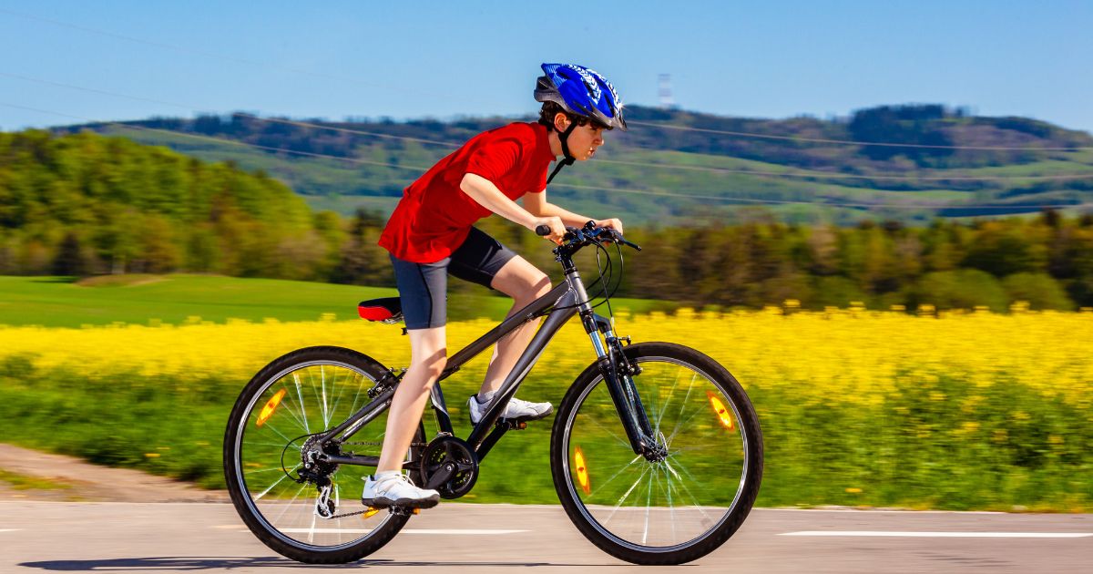 A boy rides a bike in this stock image.