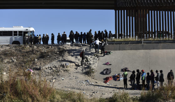 Migrants wait to get into a U.S. government bus after crossing the border from Ciudad Juarez, Mexico, to El Paso, Texas, on Dec. 12.