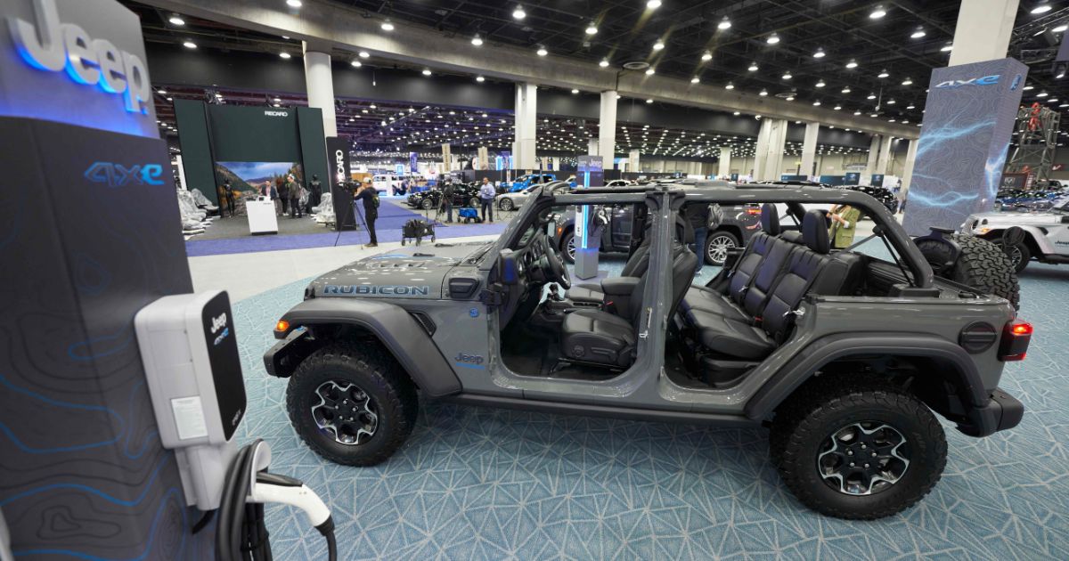 A charger stands next to a Jeep Wrangler 4xe at the 2022 North American International Auto Show in Detroit on Sept. 14.