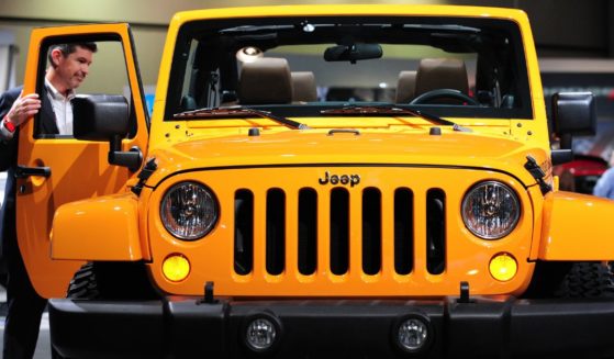 A man opens the passenger door of a Jeep Wrangler on display at the 2012 Los Angeles Auto Show, on Nov. 16, 2011, in Los Angeles.