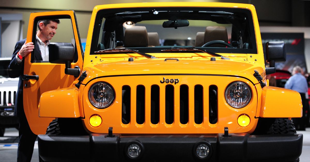 A man opens the passenger door of a Jeep Wrangler on display at the 2012 Los Angeles Auto Show, on Nov. 16, 2011, in Los Angeles.