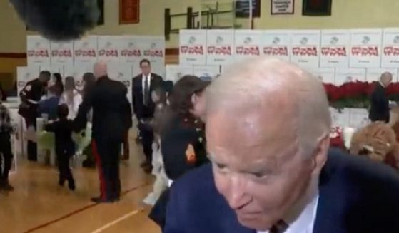 President Joe Biden stoops to hear a reporter's question Monday at a Toys for Tots event in Arlington, Virginia.