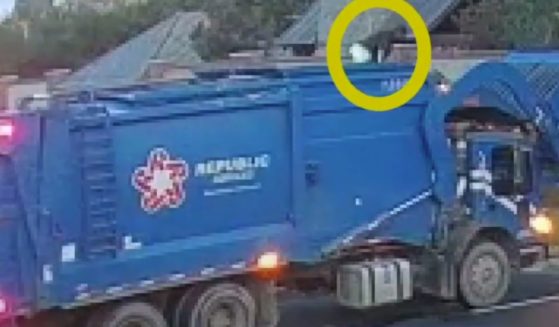A man is rescued from a dump truck in this YouTube screen shot.