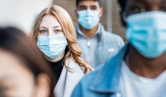 People wear masks in this stock image.