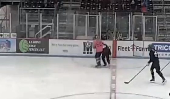 A male hockey player slams a female hockey player during a "transgender" game in Middleton, Wisconsin.
