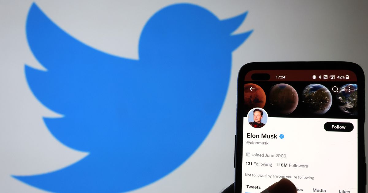 The Twitter account of Elon Musk is displayed on a smartphone with a Twitter logo in the background on November 21, 2022 in Newcastle Under Lyme, England.