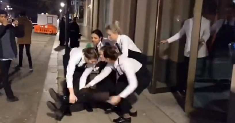 Waitresses physically dump animal rights protester on a sidewalk.