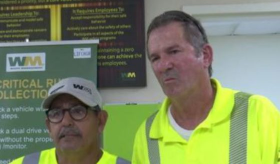 Two waste management workers saved an elderly man after he became trapped under a golf cart.