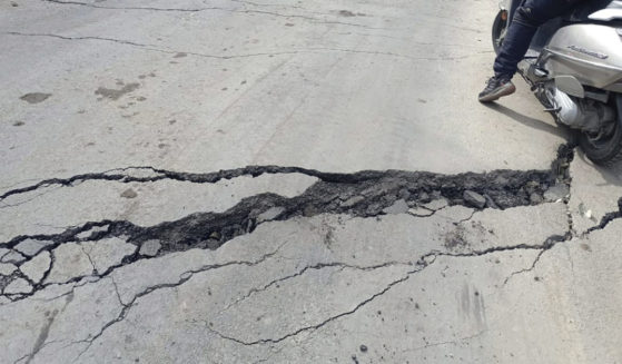 a motorist navigating his way through a crack on a road