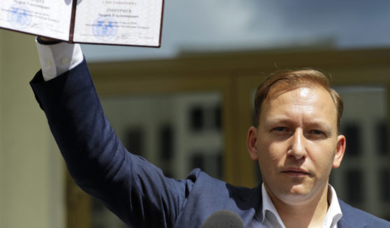 Andrey Dzmitryeu shows his presidential candidate's identification card after he was registered as a candidate in the presidential elections in Minsk, Belarus, on July 14, 2020.