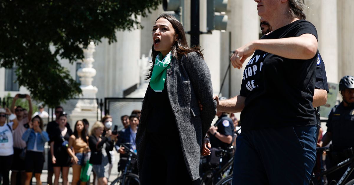 Rep. Alexandria Ocasio-Cortez (D-NY) is detained by U.S. Capitol Police Officers after participating in a sit in with activists from Center for Popular Democracy Action (CPDA) in front of the U.S. Supreme Court Building on July 19, 2022 in Washington, DC.